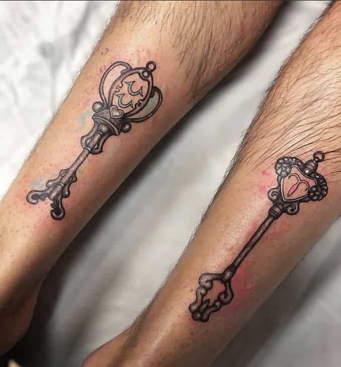 Matching black and grey tattoos of Lucy Heartfilia's Celestial Spirit Keys from Fairy Tail, featuring intricate shading and elegant details.