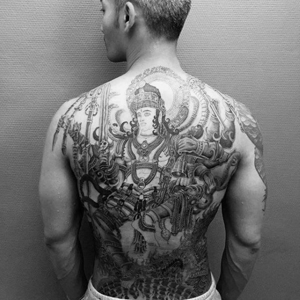 Intricate full-back tattoo of Lord Shiva in warrior form, surrounded by divine symbols, weapons, and detailed mythological elements.
