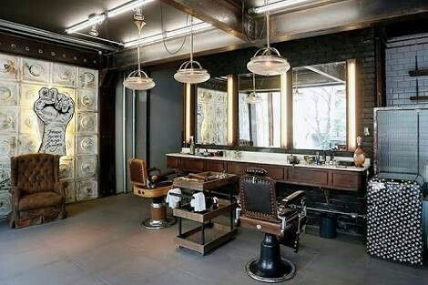 Rustic barbershop with leather chairs, vintage decor, and illuminated mirrors.