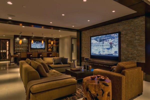 Luxurious home theater room with a large screen, cozy sofas, and a sleek bar in the background