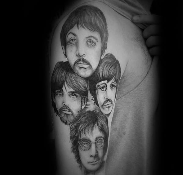 Detailed black and gray tattoo of The Beatles' faces on the upper arm, showcasing each member with realistic shading and expressive eyes.