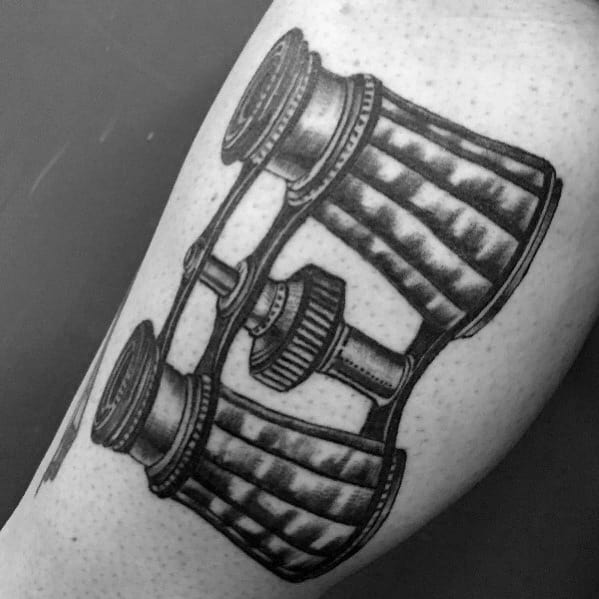 Black and grey vintage binoculars tattoo with fine shading and intricate details, giving it a classic and timeless look.