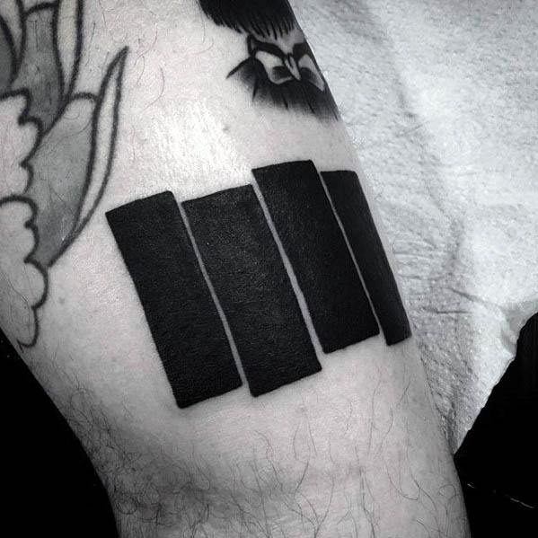 Bold and clean Black Flag bars tattooed on the upper arm, positioned at an angle to reflect iconic punk simplicity and strength.