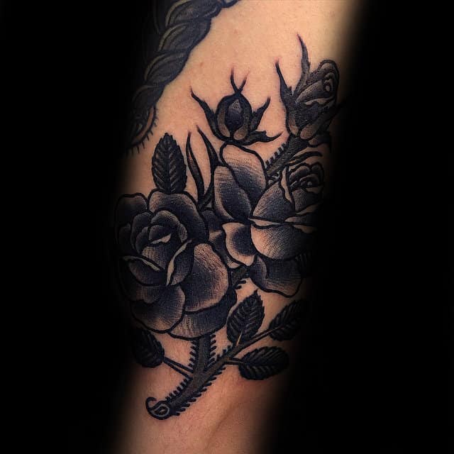Tattoo of three shaded roses and leaves on skin