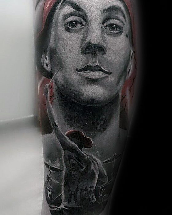Detailed black and gray tattoo of Travis Barker, capturing his face and iconic drumming pose, with intricate shading and a realistic, lifelike style.
