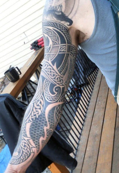Close-up view of a detailed sleeve tattoo featuring intricate patterns and designs