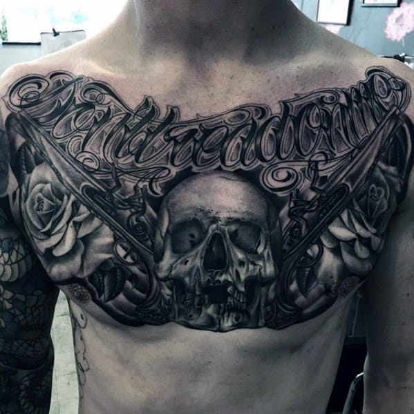 Detailed chest tattoo featuring a central skull, roses, revolvers, and ornate script text, blending gothic and Guns N' Roses-style elements.