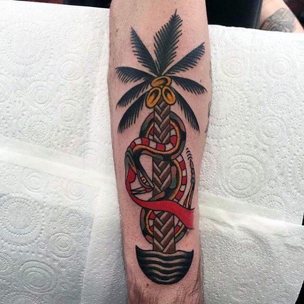 Traditional-style tattoo of a coconut palm tree with a red and yellow snake wrapped around the trunk, inked on the forearm.