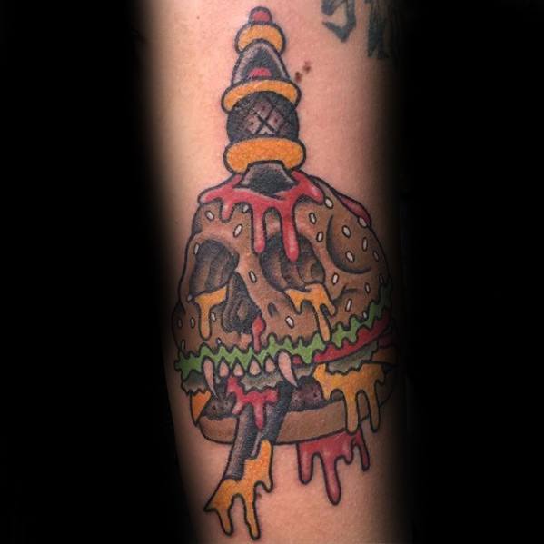 Cheeseburger tattoo design featuring a skull shape, dripping cheese, lettuce, and a sword piercing through