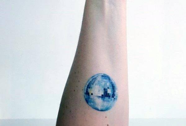 Minimalist blue disco ball tattoo on the forearm with soft shading, creating a subtle yet stylish retro-inspired design.