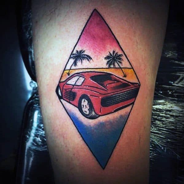 Stylish Ferrari tattoo in diamond frame with sunset colors and palm trees, evoking retro vibes and exotic luxury on man's arm.