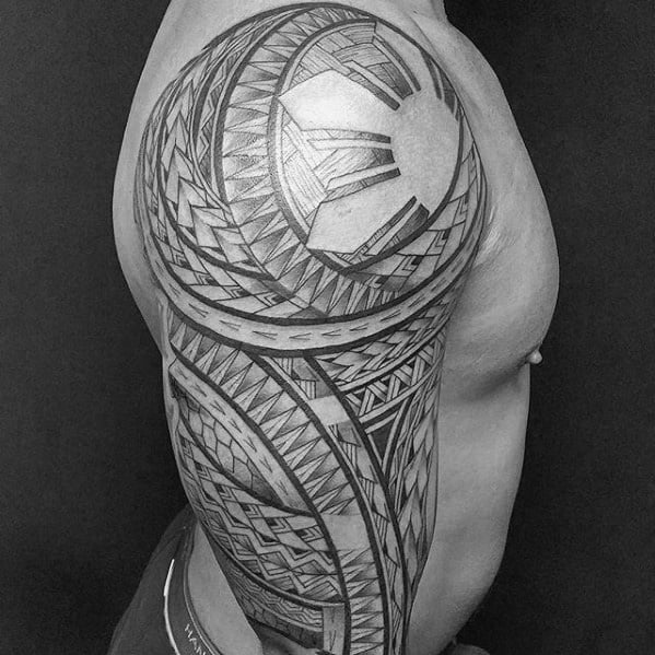 Filipino sun tattoo on the shoulder with intricate tribal weaving, bold rays, and detailed geometric bands flowing down the full upper arm.