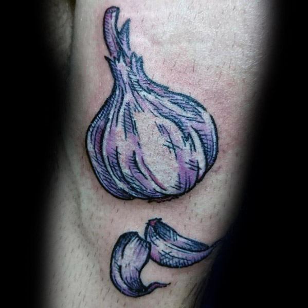 Bold garlic tattoo with a sketch-style design, featuring purple shading and peeled cloves for a textured and artistic botanical look.