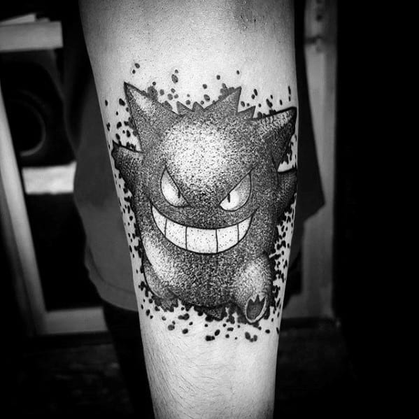 Black and grey Gengar tattoo done in dotwork style, with scattered ink splatter effect and a mischievous ghostly expression.