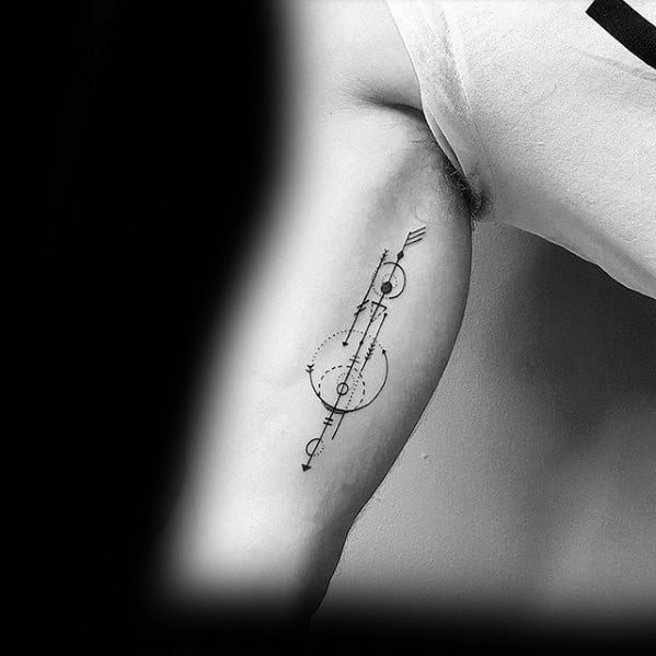Minimal geometric arrow tattoo with intersecting lines, circles, and dot accents placed vertically on the inner bicep.