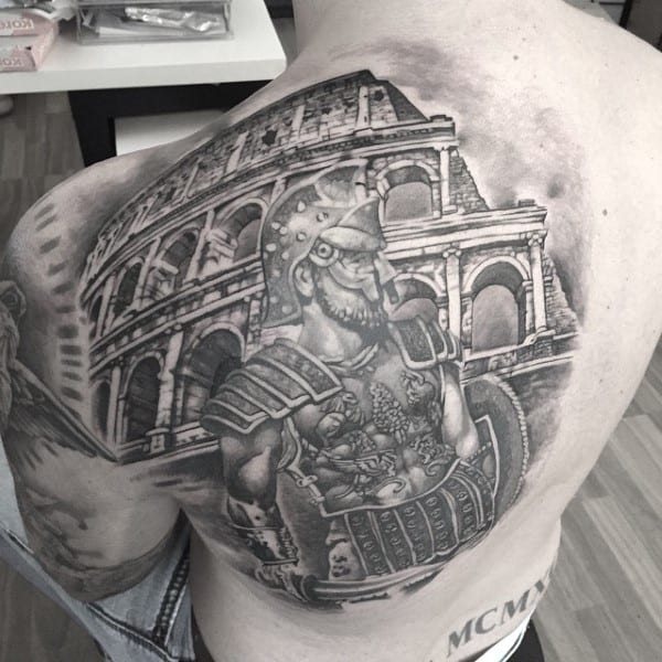 A large back tattoo of a formidable gladiator standing proud in front of the Colosseum