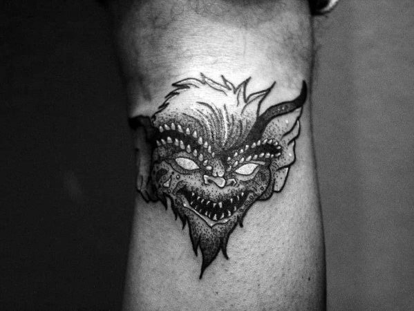 Black and gray Gremlin tattoo with intense shading, sharp teeth, and glowing eyes, creating a dark and eerie design.