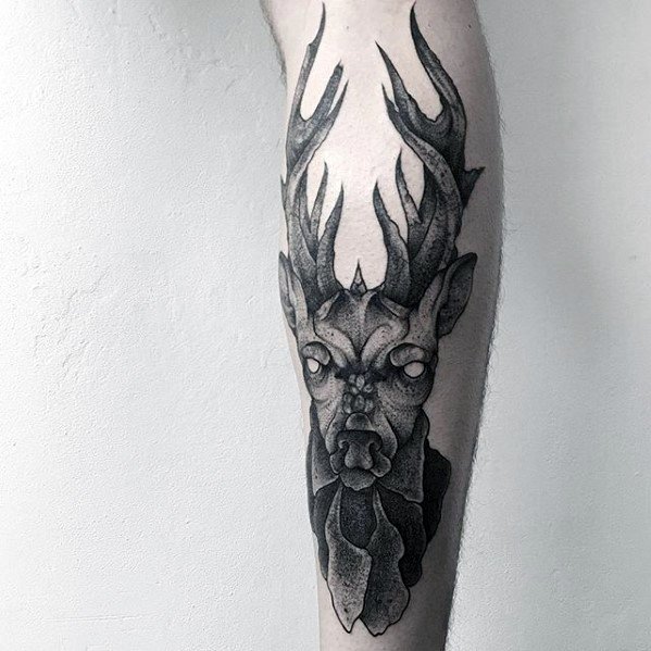 Dark fantasy-style elk tattoo on the leg, featuring bold black shading, glowing eyes, and intricate details for a mystical and eerie design.
