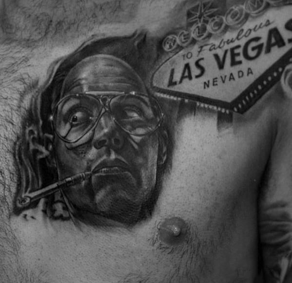 Black and white Hunter S. Thompson tattoo featuring a realistic portrait with aviator glasses, a cigarette, and the iconic "Welcome to Las Vegas" sign.