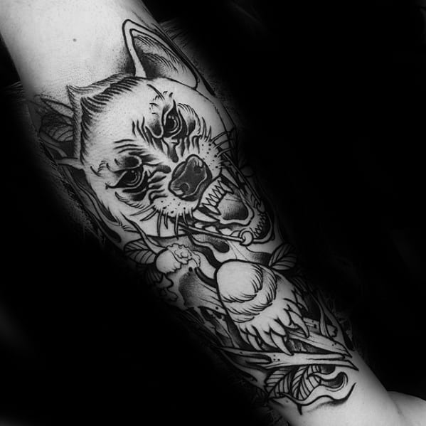 Black and grey hyena tattoo in a bold illustrative style, featuring fierce eyes, bared fangs, and dynamic floral and skull elements.