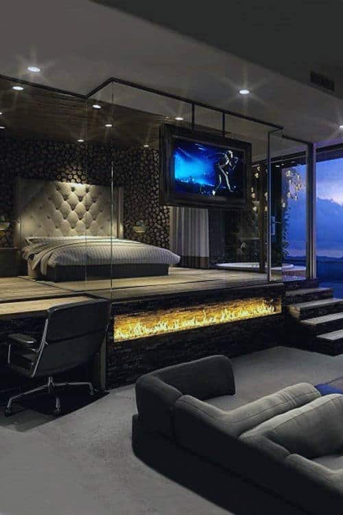 Luxurious modern bedroom with fireplace, flat screen, and panoramic window views