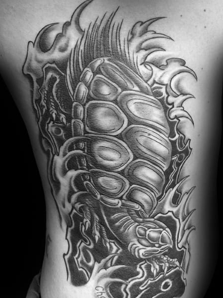 Black and grey Japanese-style turtle tattoo on the back with bold shading, flowing waves, and intricate details, symbolizing strength and longevity.