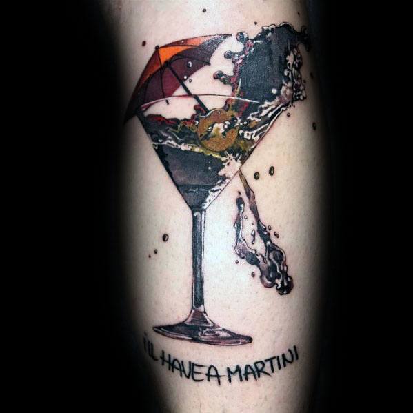 Realistic martini glass tattoo with a splash effect, an olive, and a red umbrella. The phrase "I'll have a martini" adds a playful touch.