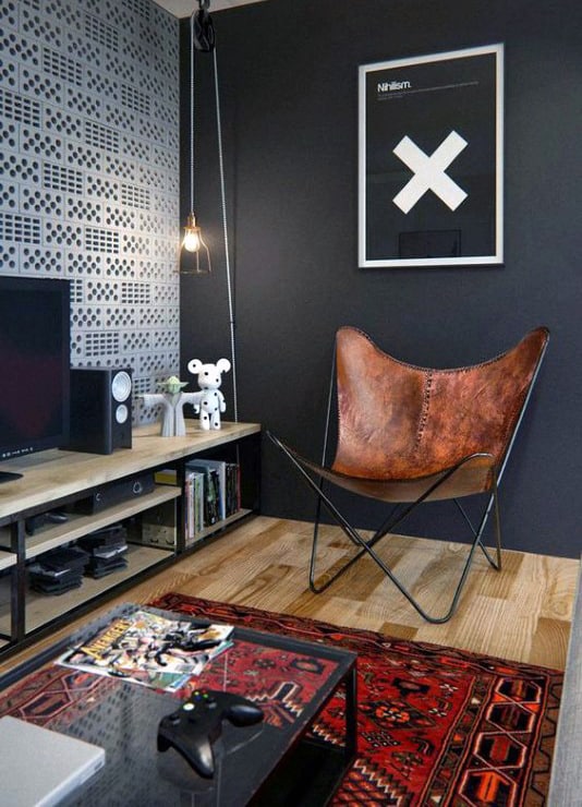 Modern living room with brown leather chair, graphic wall art, and red patterned rug.