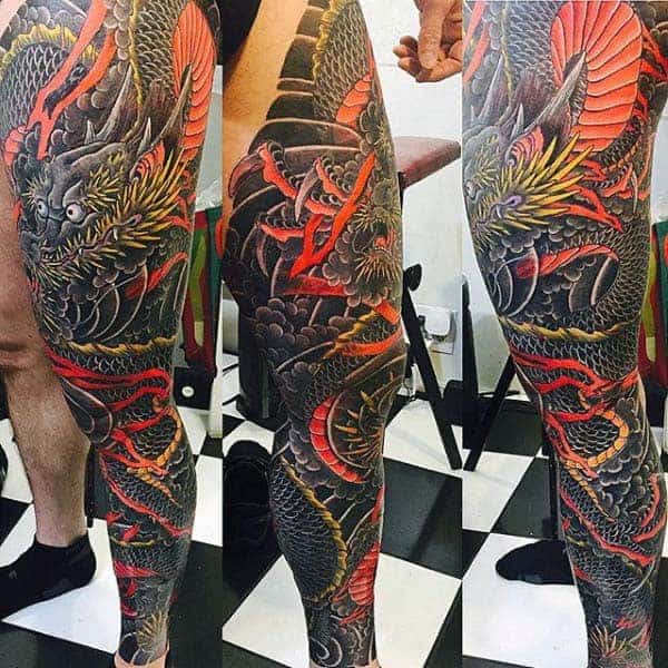 This Japanese leg sleeve tattoo features a fierce dragon intricately wrapped around the leg, highlighted by fiery red and golden hues, surrounded by bold black shading and traditional Japanese patterns, creating a dramatic and powerful visual statement