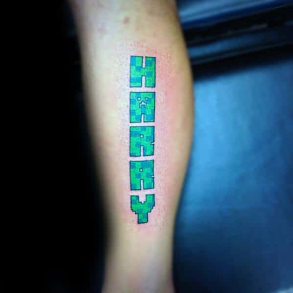 Minecraft-style tattoo spelling out “HARRY” in bold, green pixelated letters with a Creeper texture, vertically aligned on the leg.