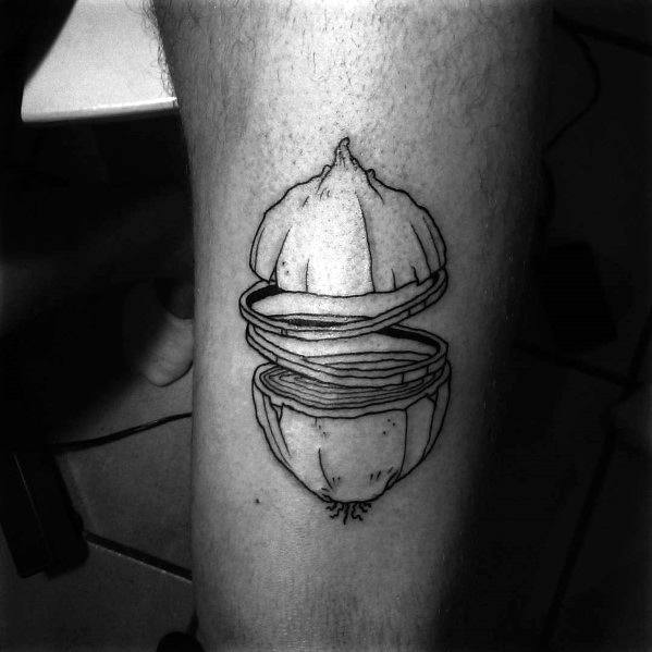 Black ink tattoo of a floating, sliced onion on the leg, featuring fine line details and a surreal, layered design for a unique artistic look.