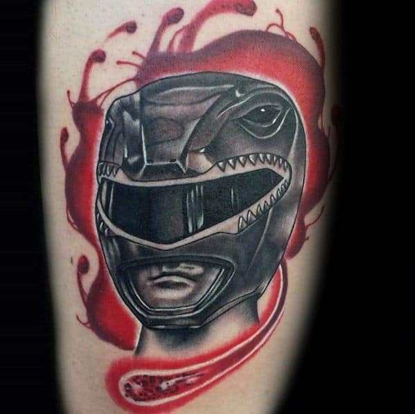 Bold Black Ranger helmet tattoo with red abstract background and intense shading for a dramatic, high-contrast look on the arm.