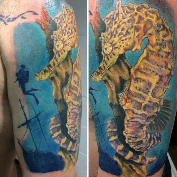 Realistic seahorse tattoo on upper arm, featuring rich yellow tones, an underwater shipwreck scene, and deep blue hues for a vibrant oceanic look.