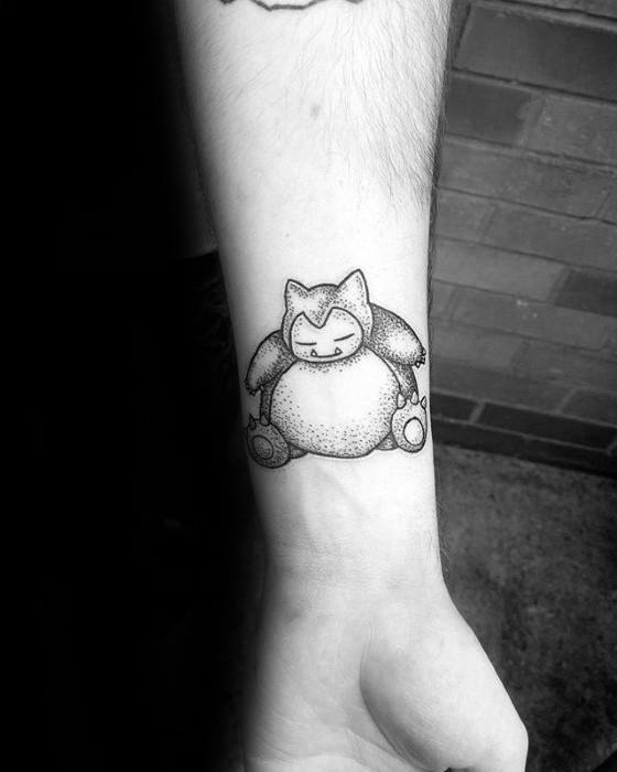Small Snorlax tattoo on wrist with fine dotwork shading and a peaceful expression in a seated pose.