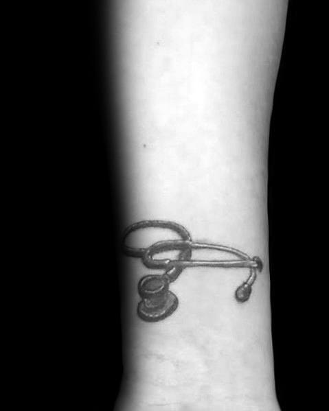 Small and minimalistic stethoscope tattoo on the wrist, symbolizing dedication to the medical profession and a passion for healthcare.