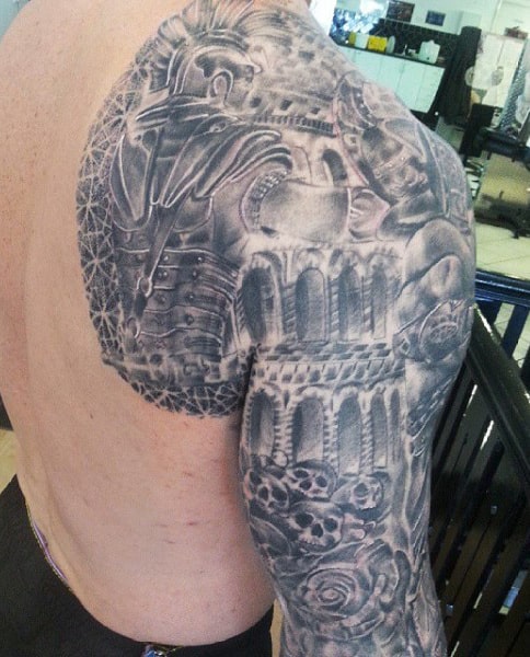 Detailed black and gray tattoo of a gladiator with Roman architecture on upper arm and shoulder