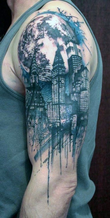 Arm tattoo of a city skyline with skyscrapers and artistic splashes of ink