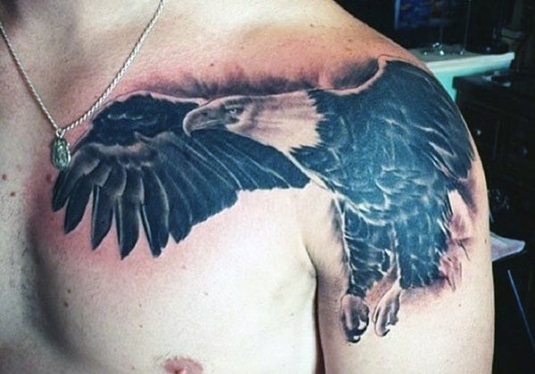 Tattoo of an eagle with wings spread across a person's shoulder and upper arm