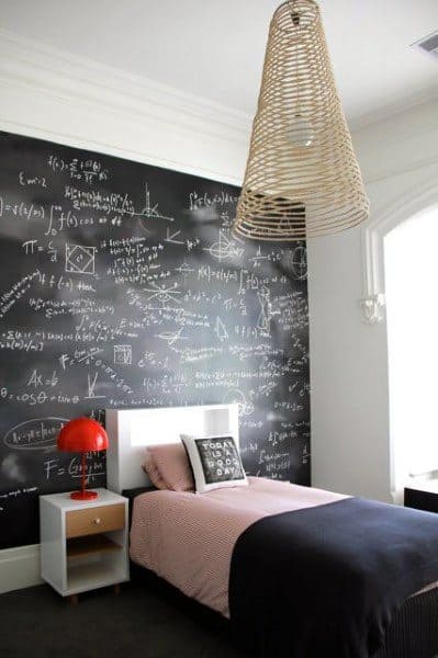 Bedroom with a chalkboard wall covered in equations, a single bed, red lamp, and a woven pendant light