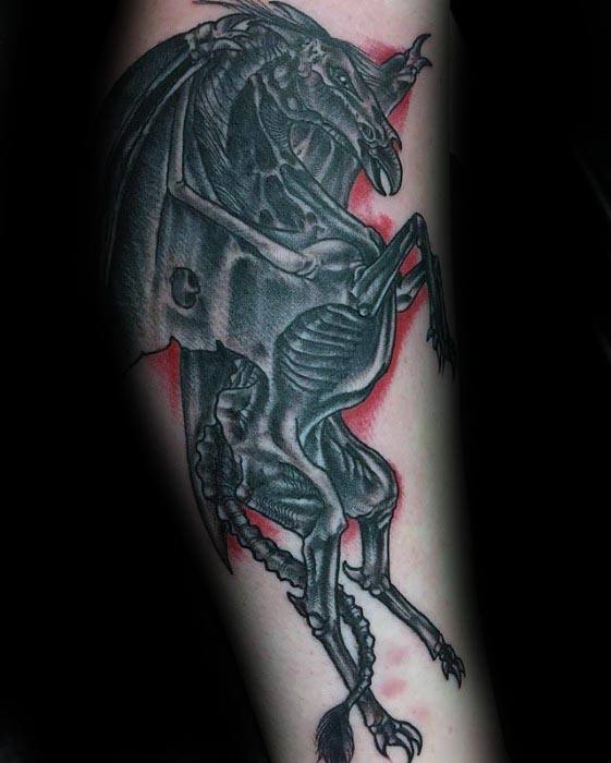 Highly detailed Thestral tattoo with intense shading and a red glow effect, capturing a fierce pose on the forearm.