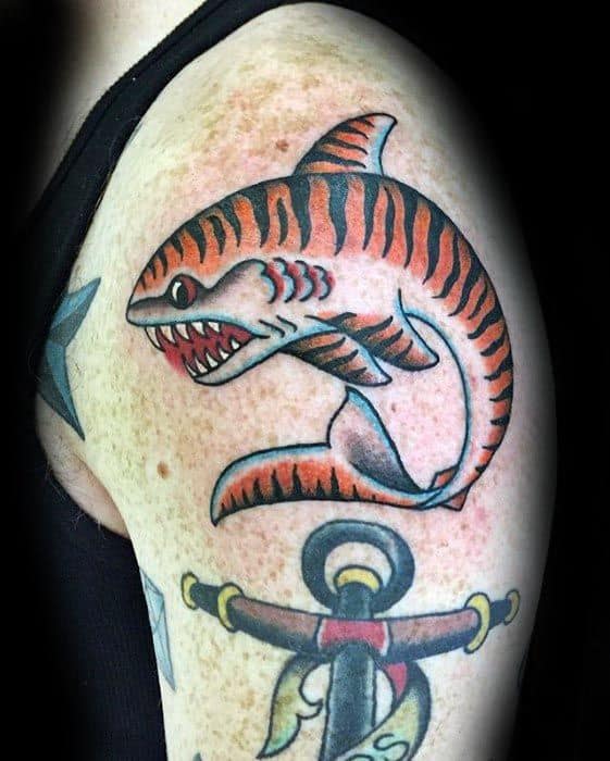 Traditional tiger shark tattoo on the upper arm with bold red-orange stripes, sharp teeth, and classic old-school shading.