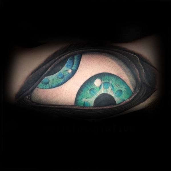 Tool-inspired tattoo of two vibrant green-blue eyes peering through a realistic skin tear, creating a surreal and intense visual effect.