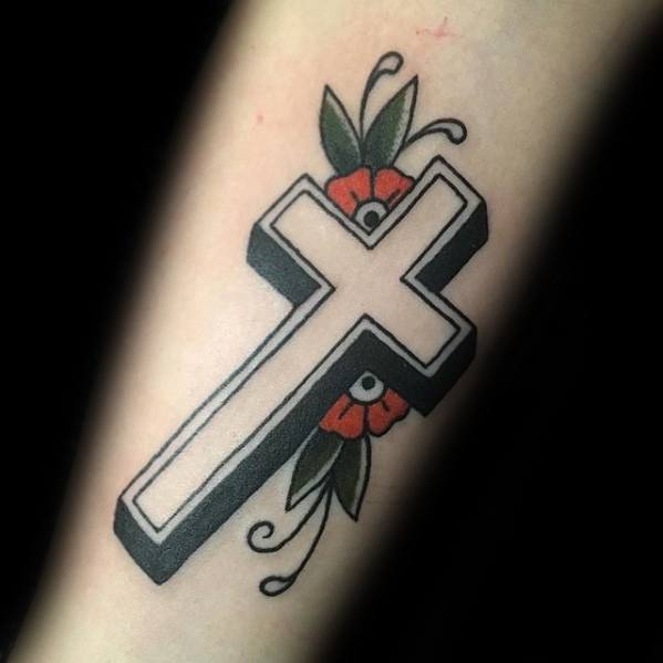 Bold 3D white cross tattoo with black shading, accented by red flowers and green leaves, in a traditional style on the forearm.