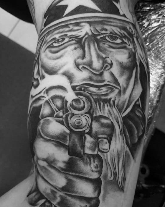 Intense black and gray Uncle Sam tattoo with dramatic shading, pointing a gun directly forward for a bold and confrontational design.