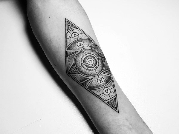 Geometric Witcher tattoo on the forearm featuring magical sign symbols inside a detailed dotwork diamond-shaped mandala design.