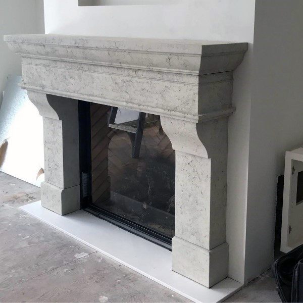 Elegant mantel-style concrete fireplace with a classic carved design, adding timeless sophistication to any room.