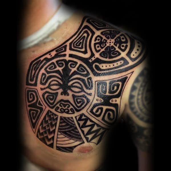A Maori tribal shoulder tattoo with intricate black geometric and spiral patterns