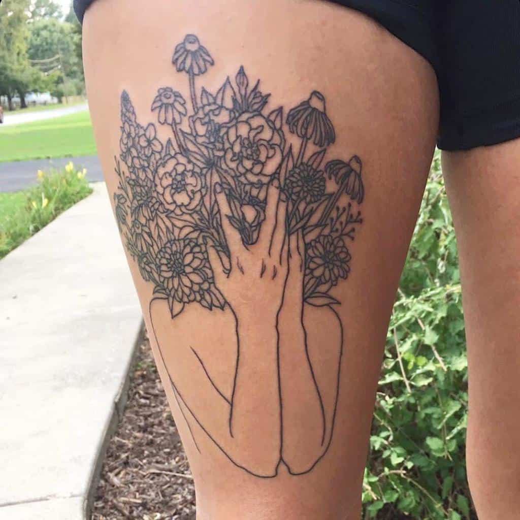 Minimalist fine-line tattoo of a faceless figure with hands covering their face, transforming into a bouquet of blooming flowers, including marigolds