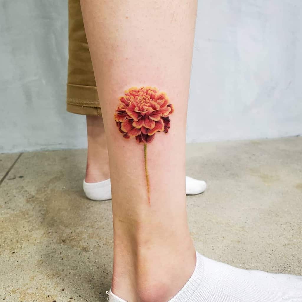 A realistic colorful marigold tattoo is displayed