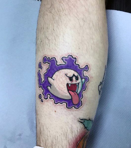 Mario ghost tattoo featuring Boo with its tongue out, emerging from a purple splatter design, inked with bold outlines and vibrant colors.